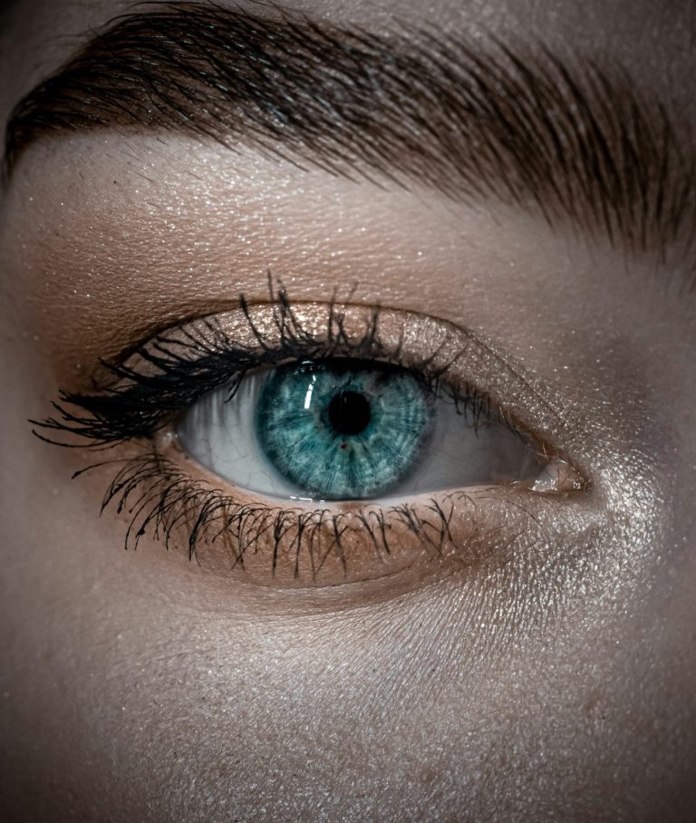Symbolfoto Auge Nahaufnahme eines menschlichen Auges mit hellblauer Iris und betonten Wimpern.